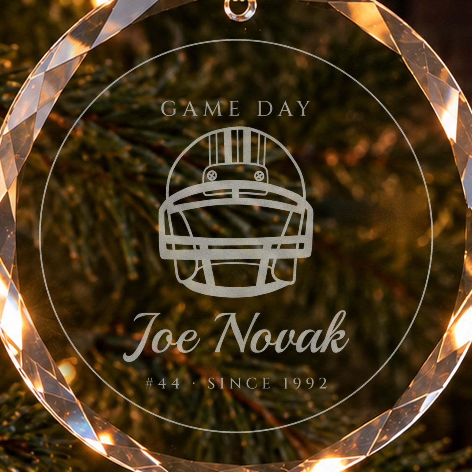Close-up of the frosted engraving on the football Christmas ornament: a football helmet, GAME DAY, Joe Novak, #44 · SINCE 1992