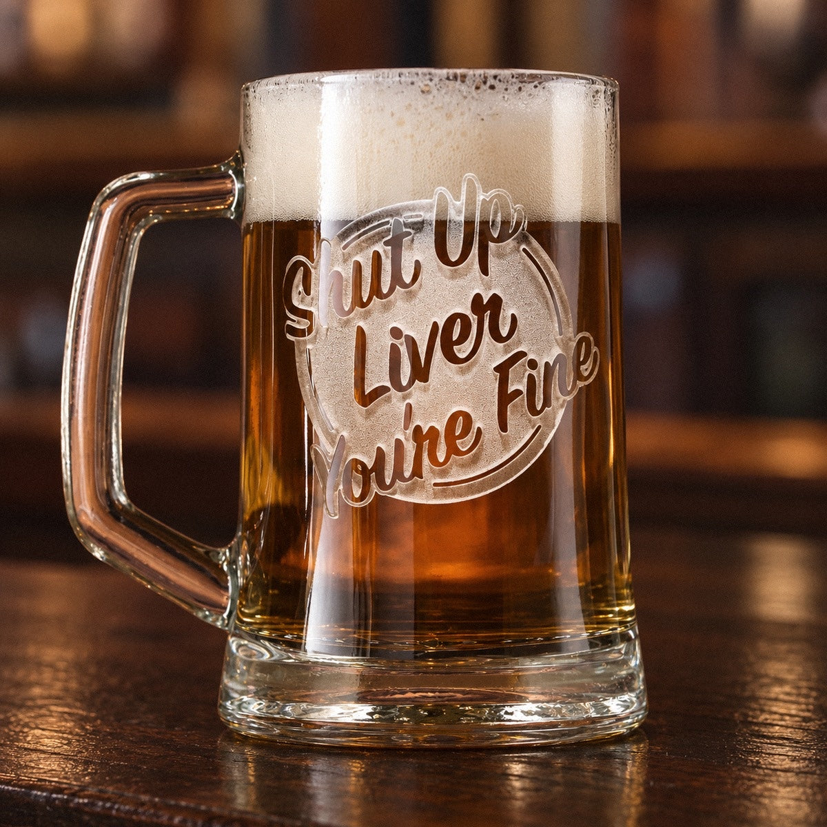 Funny beer mug full of amber ale on a walnut bar, sand-carved with Shut Up, Liver, You're Fine in a hand-lettered badge, a funny beer mug for guys