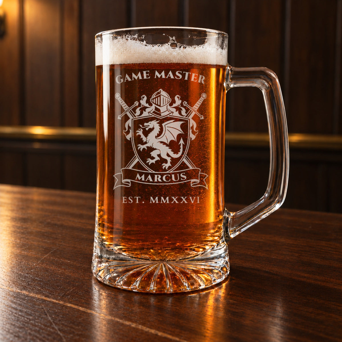 Game master gift for a tabletop gamer: a personalized 25 oz glass beer mug on a walnut bar, engraved with a dragon crest, GAME MASTER, MARCUS and EST. MMXXVI