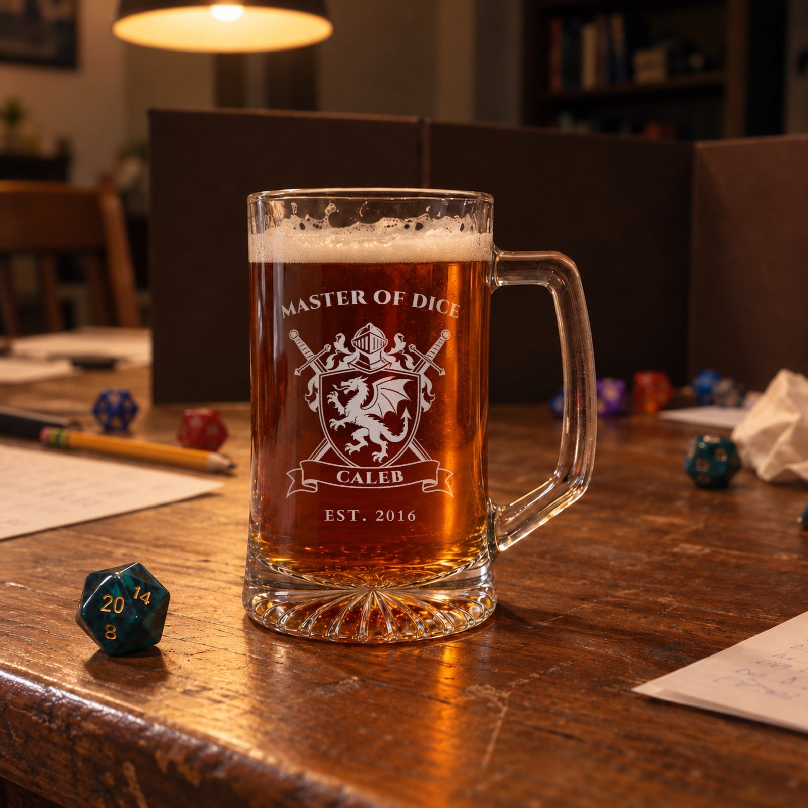 Personalized dragon crest beer mug on a game night table with dice and a game screen, engraved MASTER OF DICE, CALEB and EST. 2016