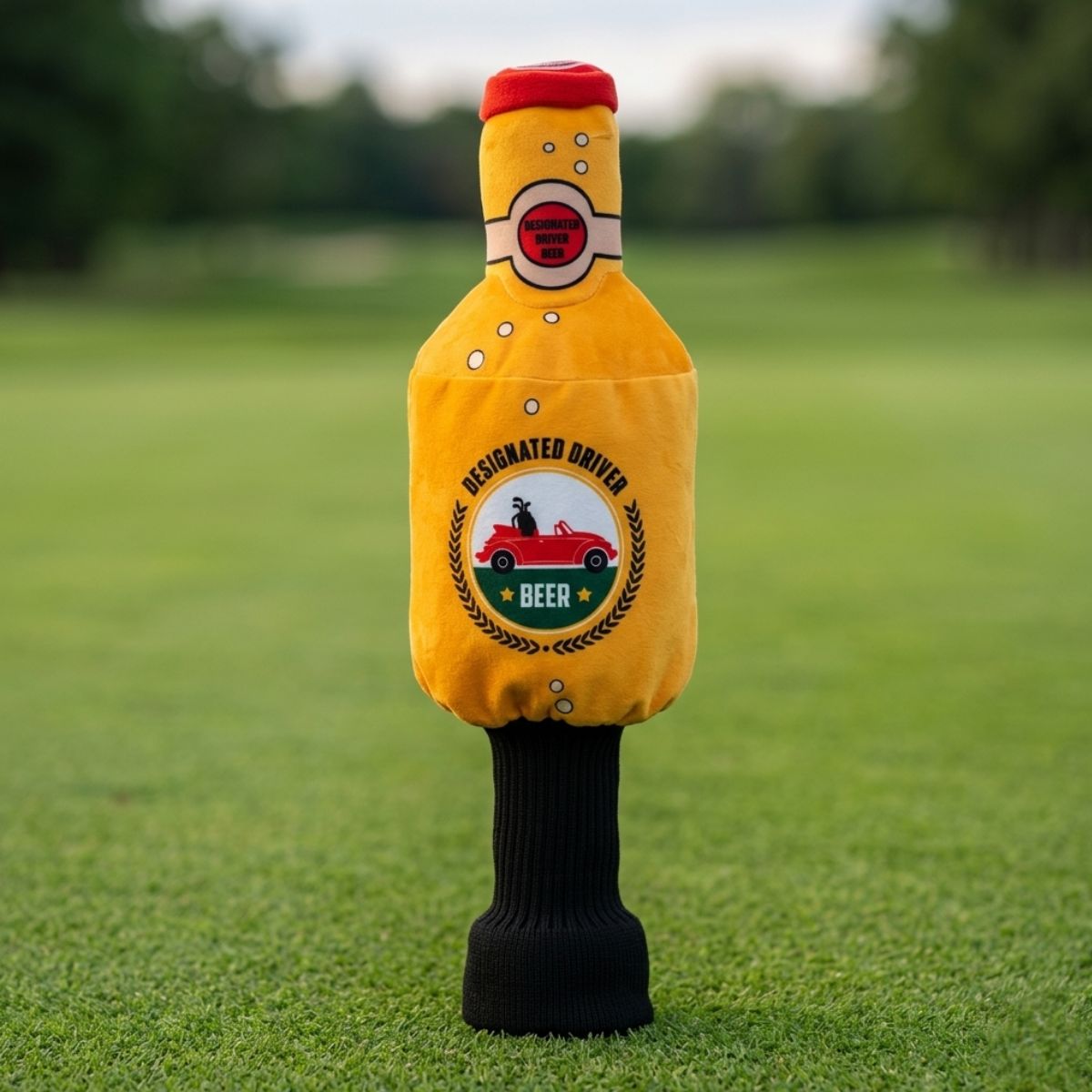 Golf club head cover shaped like a beer bottle on a grassy background