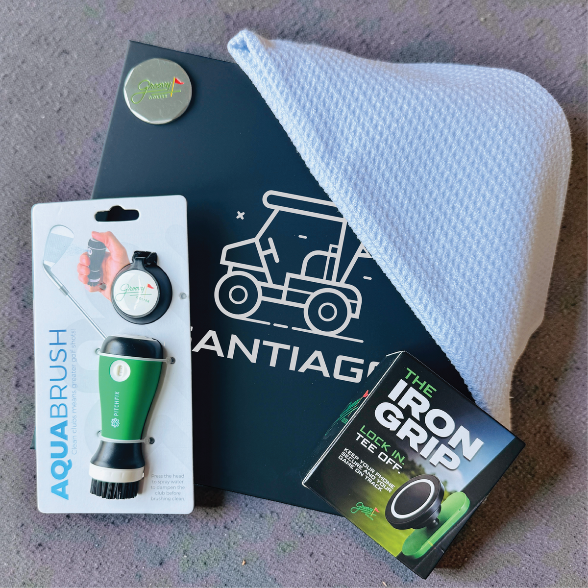 Golfer's gift box featuring a name-engraved keepsake box, club cleaner, waffle microfiber towel, ball marker and magnetic phone mount.