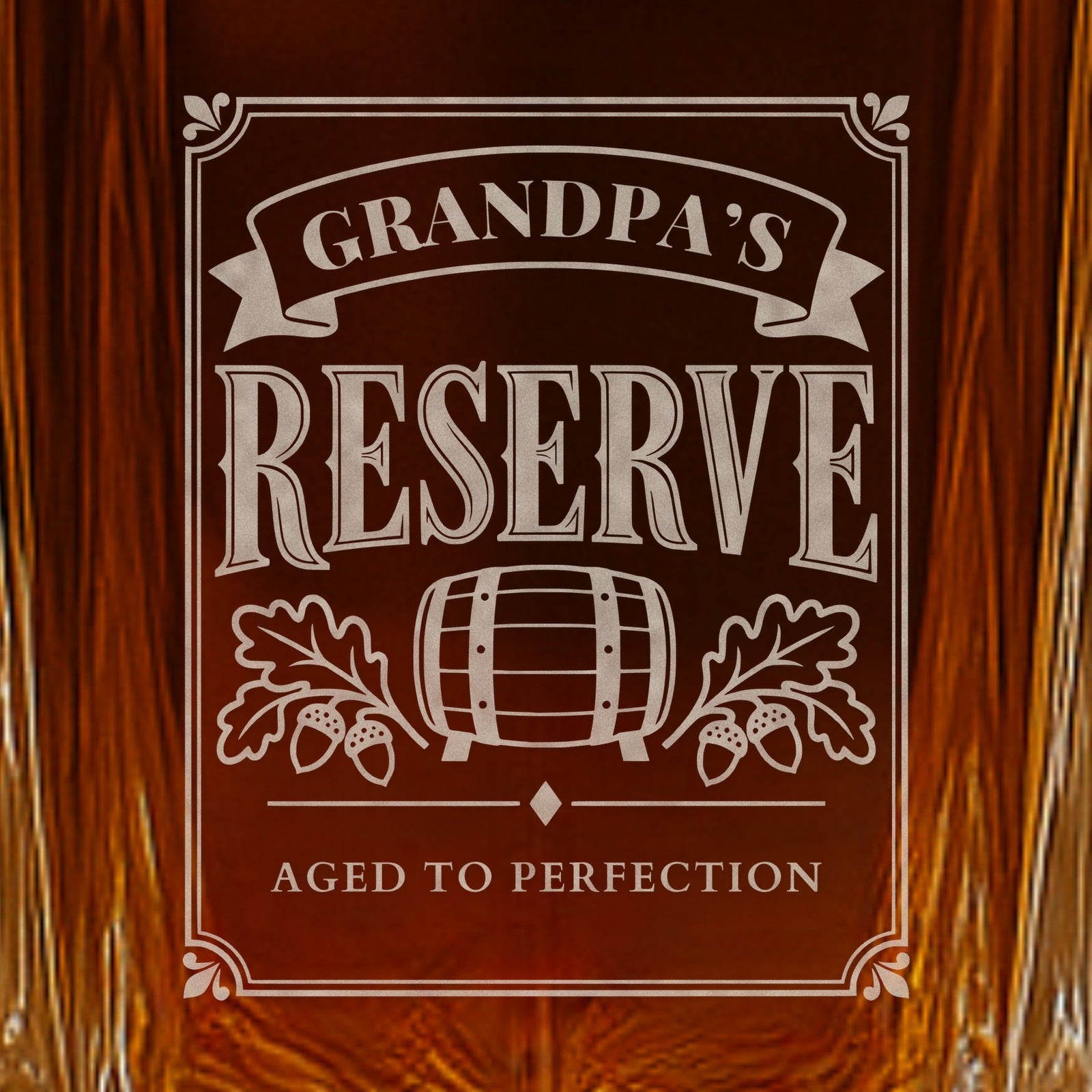 Close-up of the frosted Grandpa's Reserve engraving on a whiskey decanter: a ribbon, barrel and oak leaves over the line Aged to Perfection