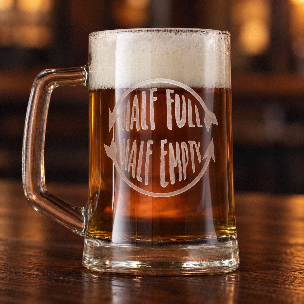 Half full half empty beer mug full of amber ale on a walnut bar, sand-carved with HALF FULL and HALF EMPTY inside a circling arrow