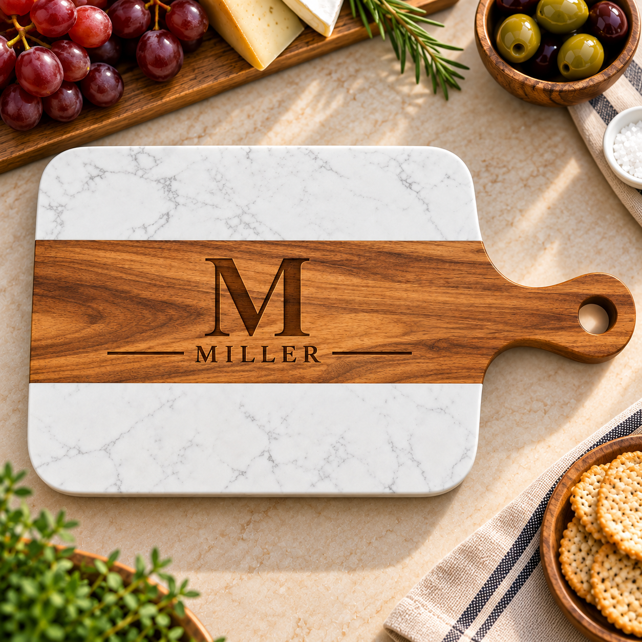 Heritage Monogram Serving Board with an acacia wood band engraved with a large M and MILLER between white marble ends, a personalized charcuterie board for him