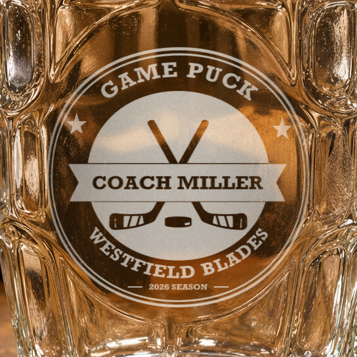 Close-up of the frosted laser engraving on the hockey coach stein, showing the hockey crest, the Coach Miller banner and the team name arc