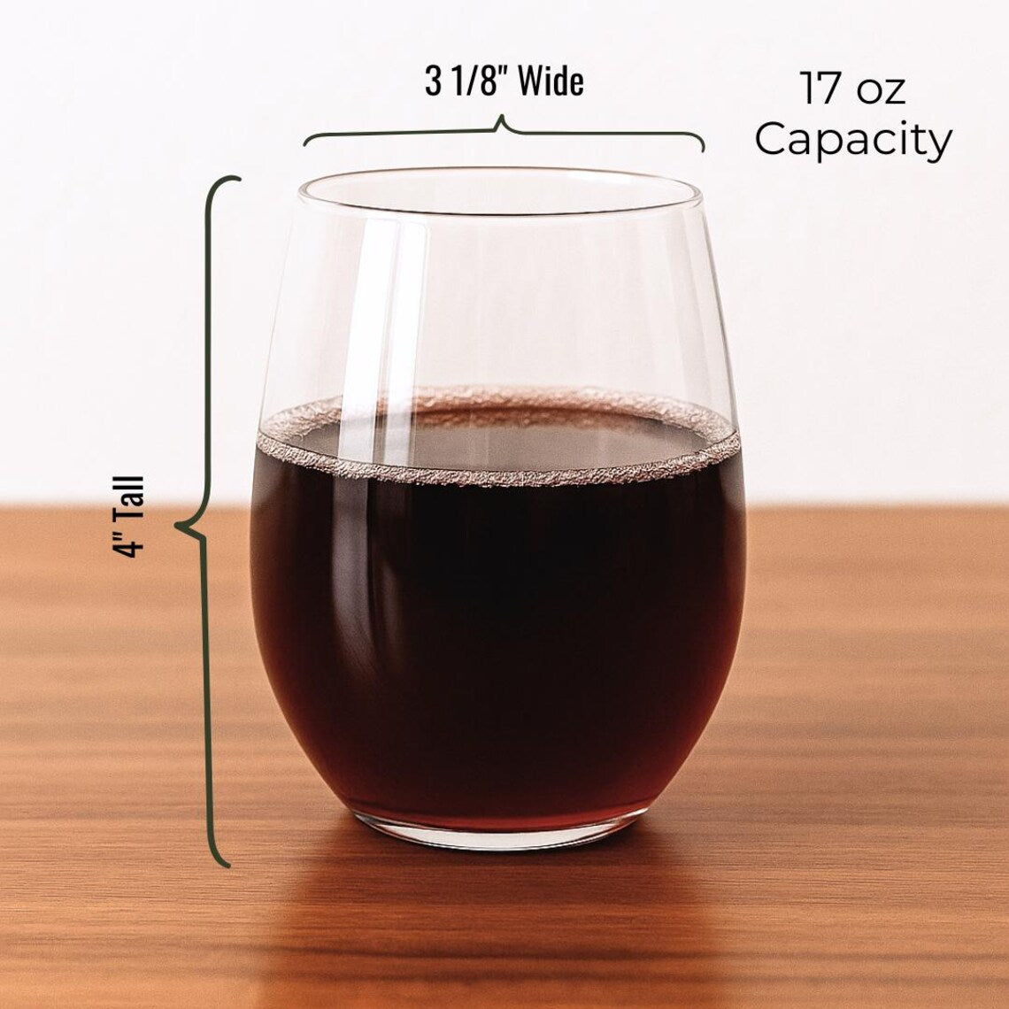 Stemless wine glass filled with red wine, displayed with dimension callouts showing 4" tall and 3 1/8" wide opening, 17 oz capacity