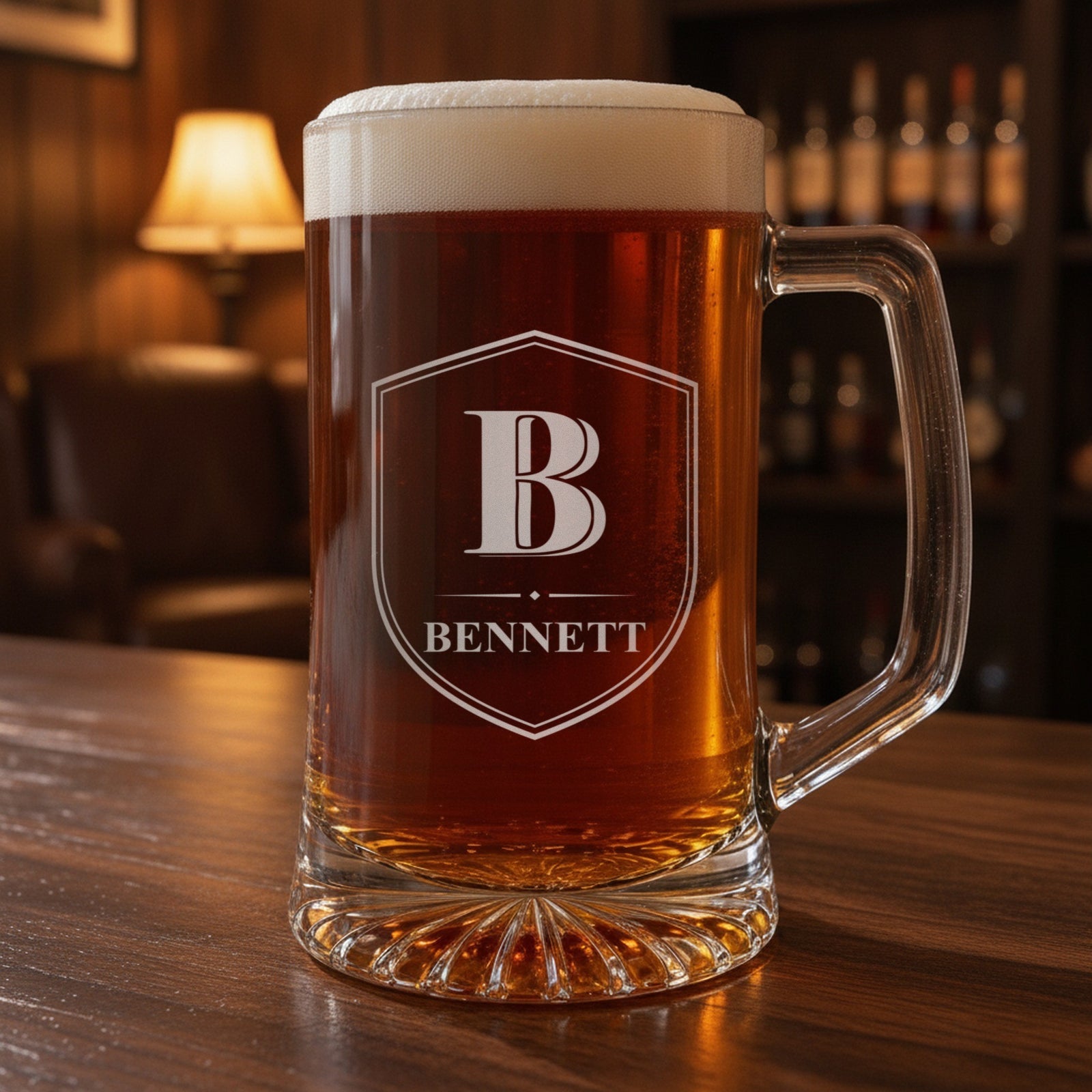 Personalized monogram beer stein on a walnut home bar, frosted Shield Crest engraving with a large initial B and the last name Bennett