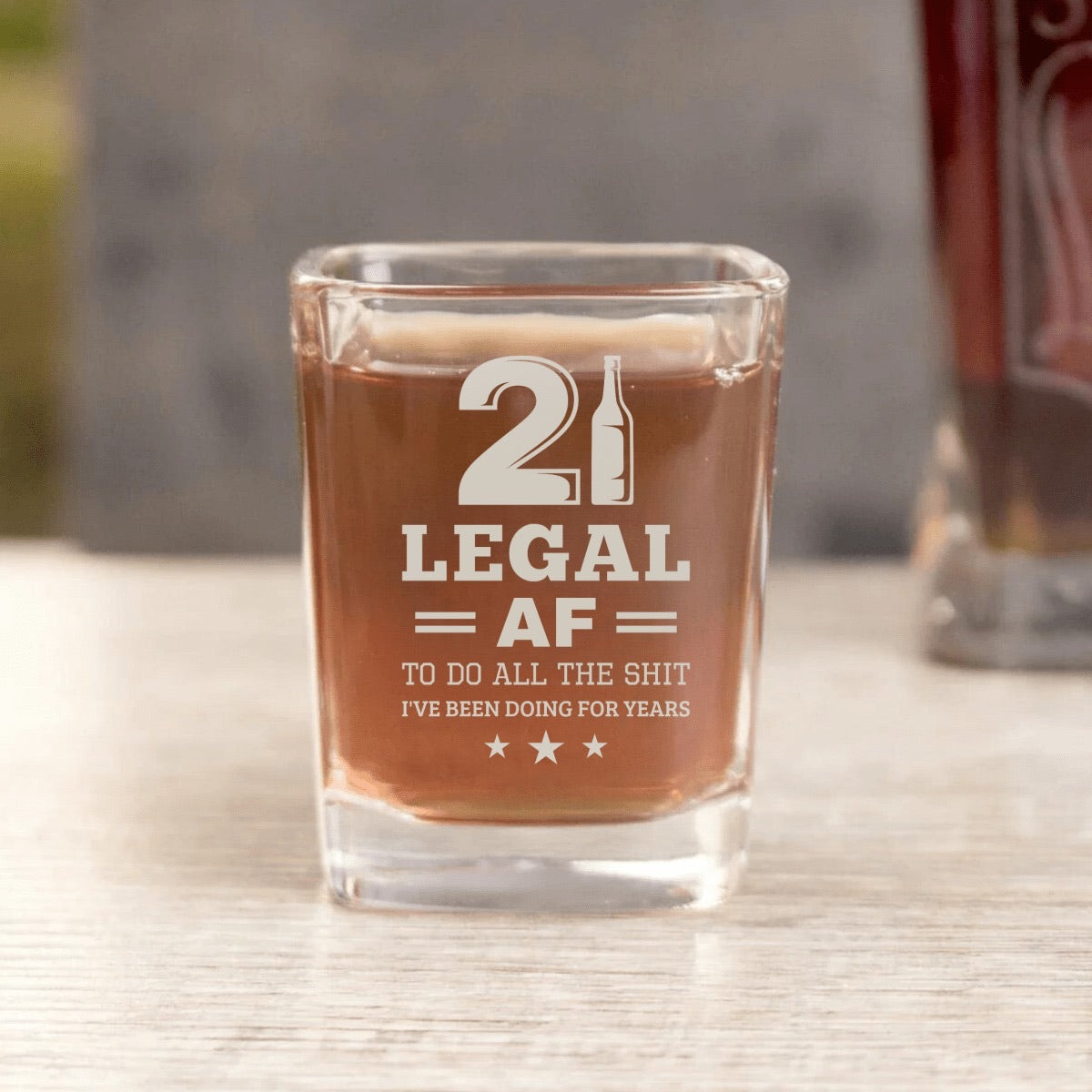 Real photo of the Legal AF 21st birthday shot glass filled with whiskey, engraved with 21, LEGAL AF and the joke line under it