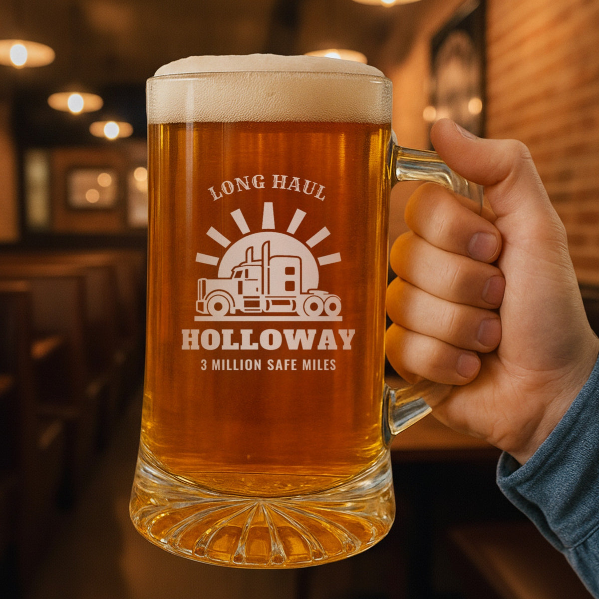 Hand holding the personalized trucker beer stein in a pub, engraved LONG HAUL over the semi truck, HOLLOWAY and 3 MILLION SAFE MILES