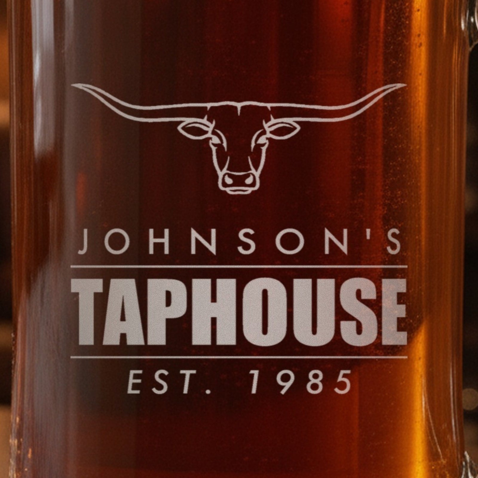 Close-up of the frosted laser engraving on the Taphouse stein: a longhorn steer, the name Johnson's, Taphouse in bold and Est. 1985