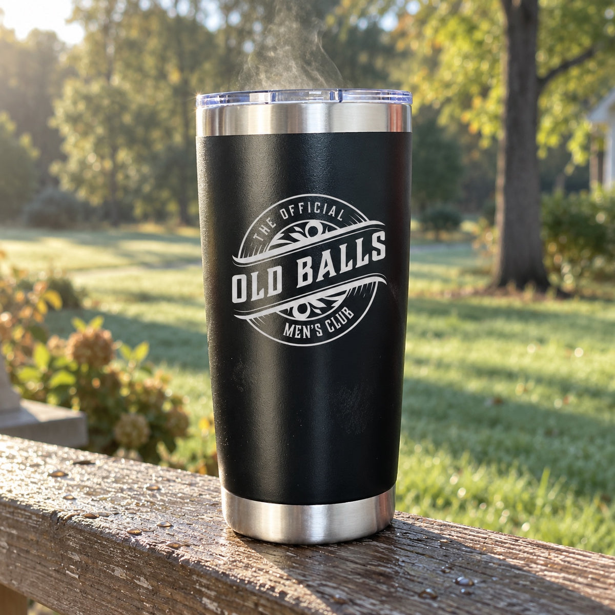 Old Balls Men's Club funny old man tumbler, a black 20 oz insulated tumbler engraved with the club badge, steaming on a porch railing