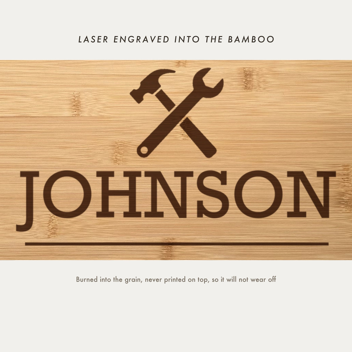 Close view of the crossed hammer and wrench emblem laser engraved into the bamboo grain above the family name in slab serif capitals.