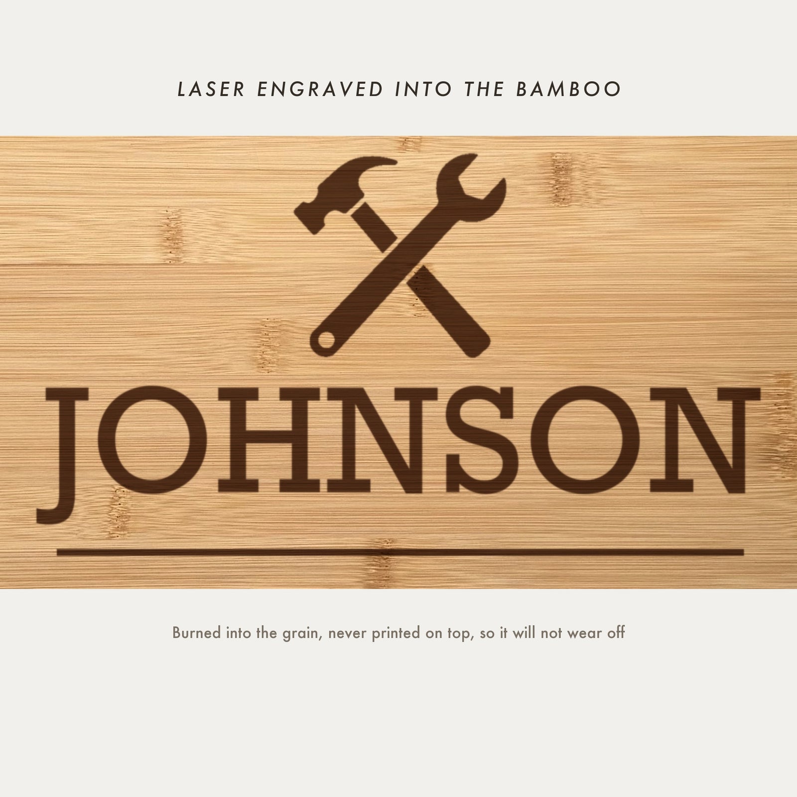 Close view of the crossed hammer and wrench emblem laser engraved into the bamboo grain above the family name in slab serif capitals.