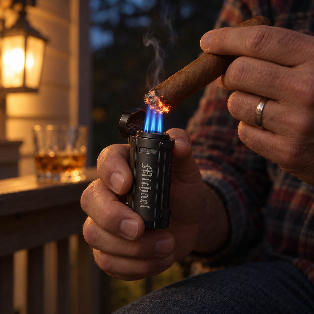 A man lights his cigar on the porch with a personalized black quad torch cigar lighter, four blue flames and his name engraved