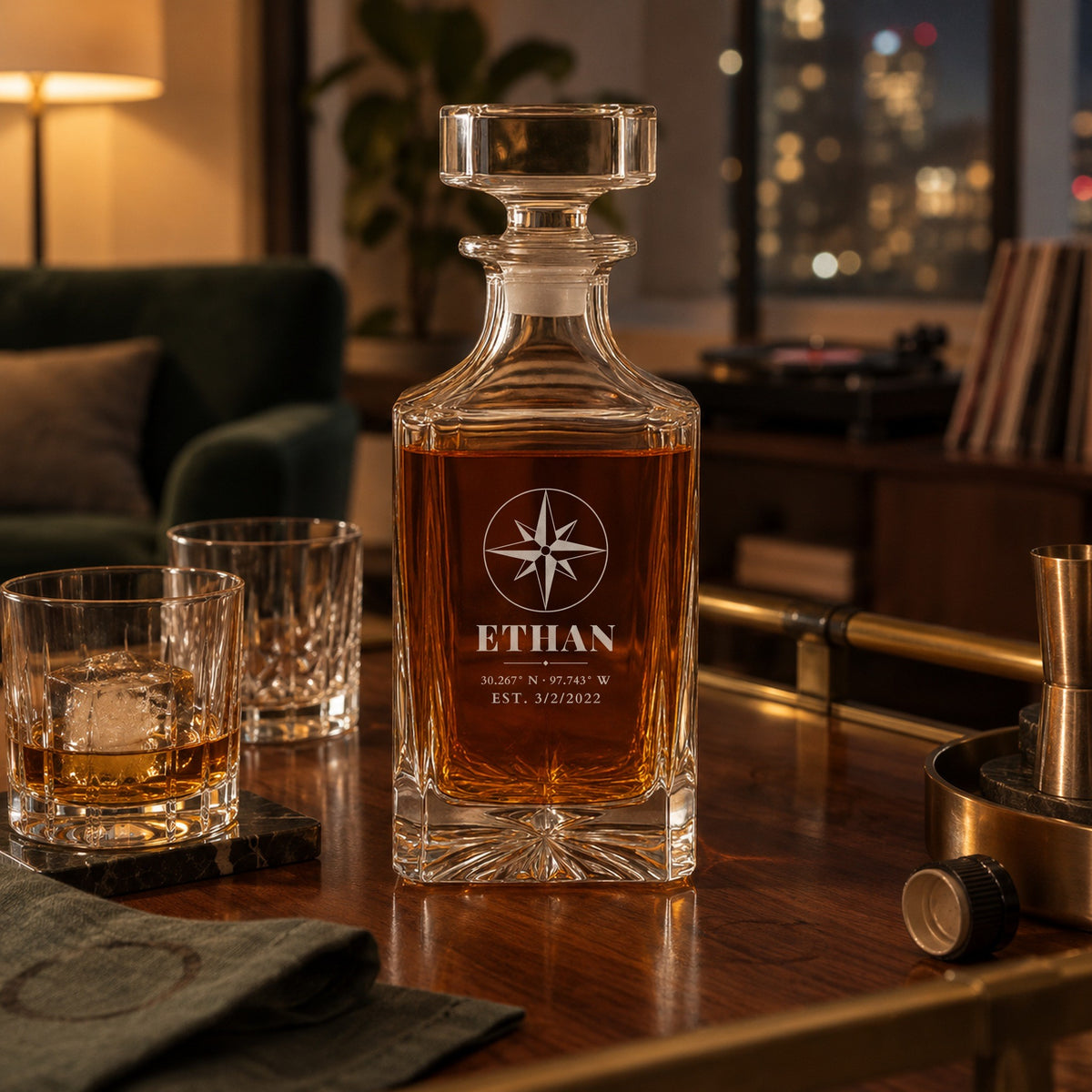 Engraved whiskey decanter for boyfriend on a walnut bar cart in his apartment, his name Ethan over Austin coordinates, with two crystal rocks glasses