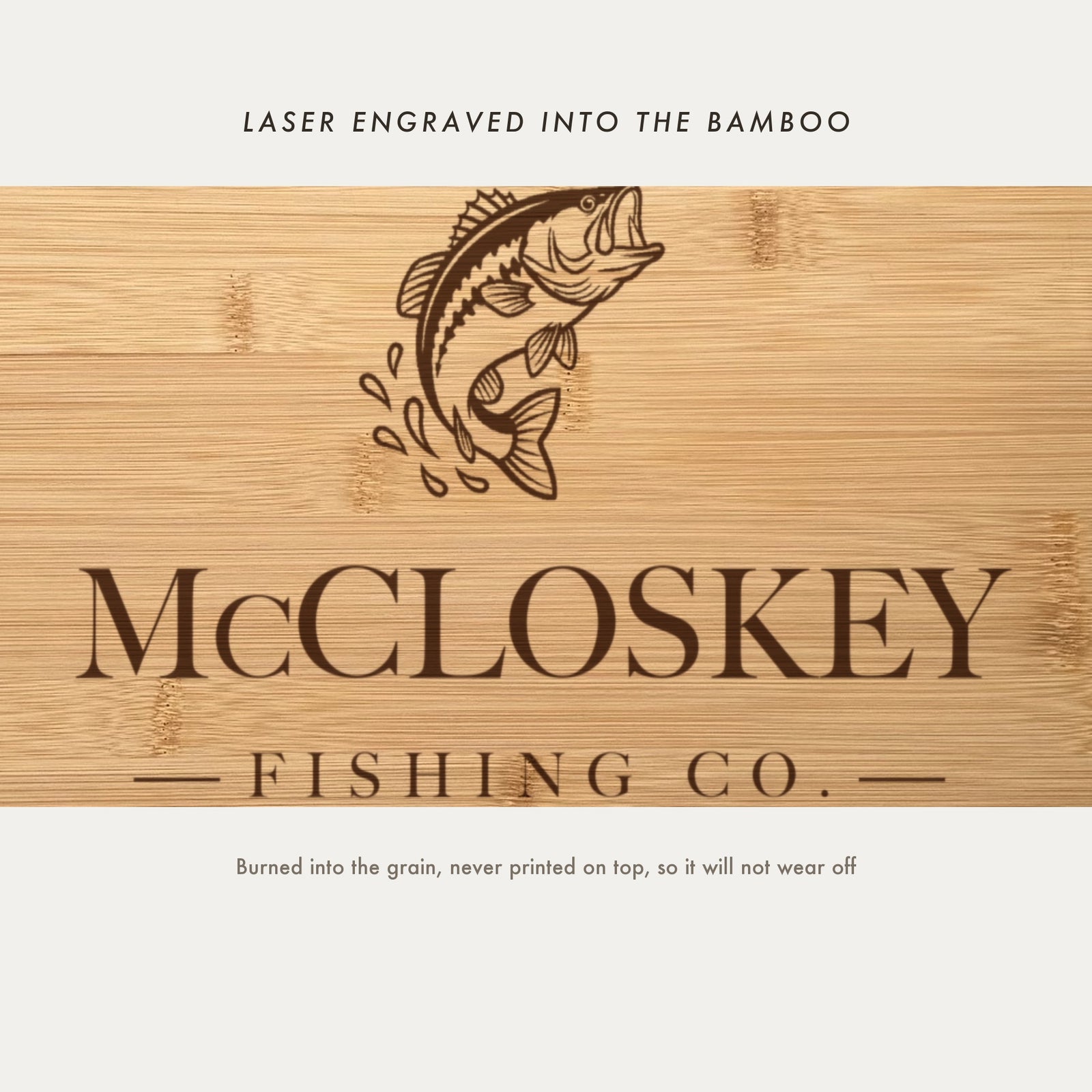 Close view of the leaping bass and water splash laser engraved into the bamboo grain above the family name in a high contrast serif.