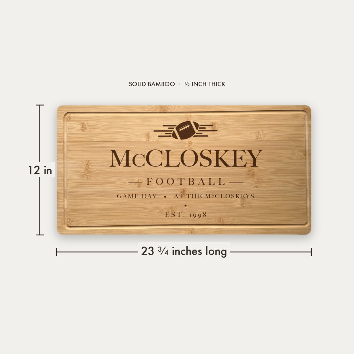 Size guide for the personalized football tailgate cutting board, 23 and three quarter inches long by 12 inches wide in half inch thick solid bamboo.