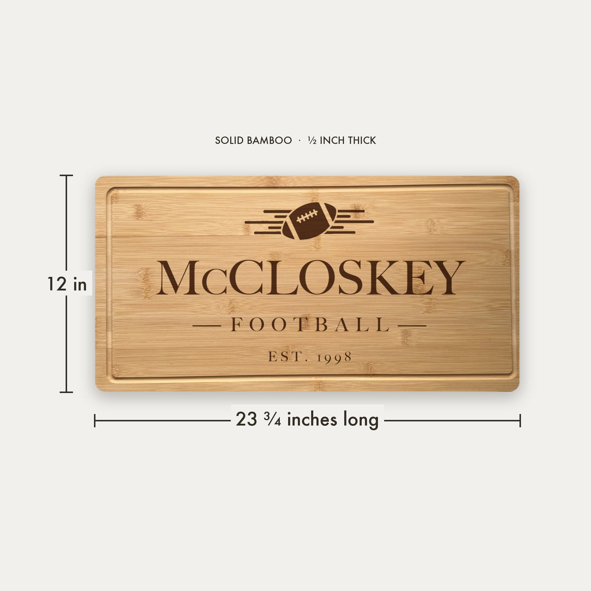 Size guide for the personalized football tailgate cutting board, 23 and three quarter inches long by 12 inches wide in half inch thick solid bamboo.