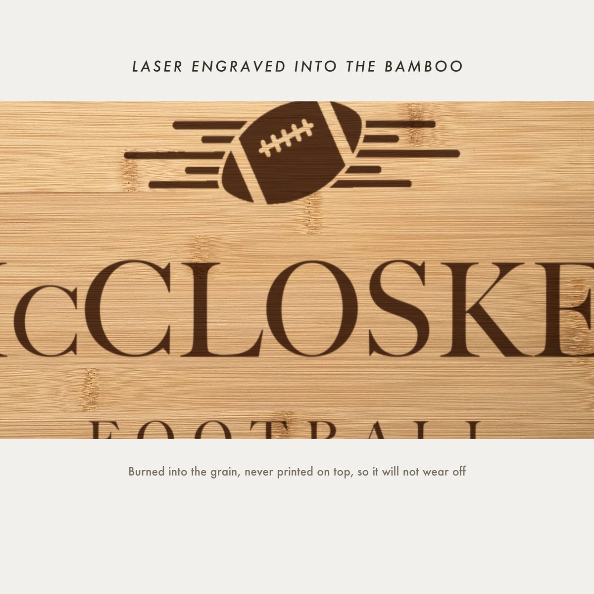 Close view of the football with speed lines laser engraved into the bamboo grain above the family name in a high contrast serif.