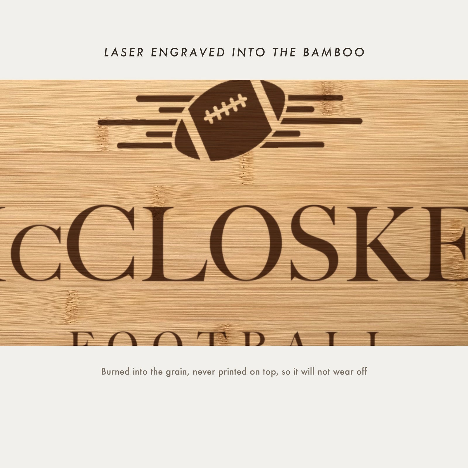 Close view of the football with speed lines laser engraved into the bamboo grain above the family name in a high contrast serif.