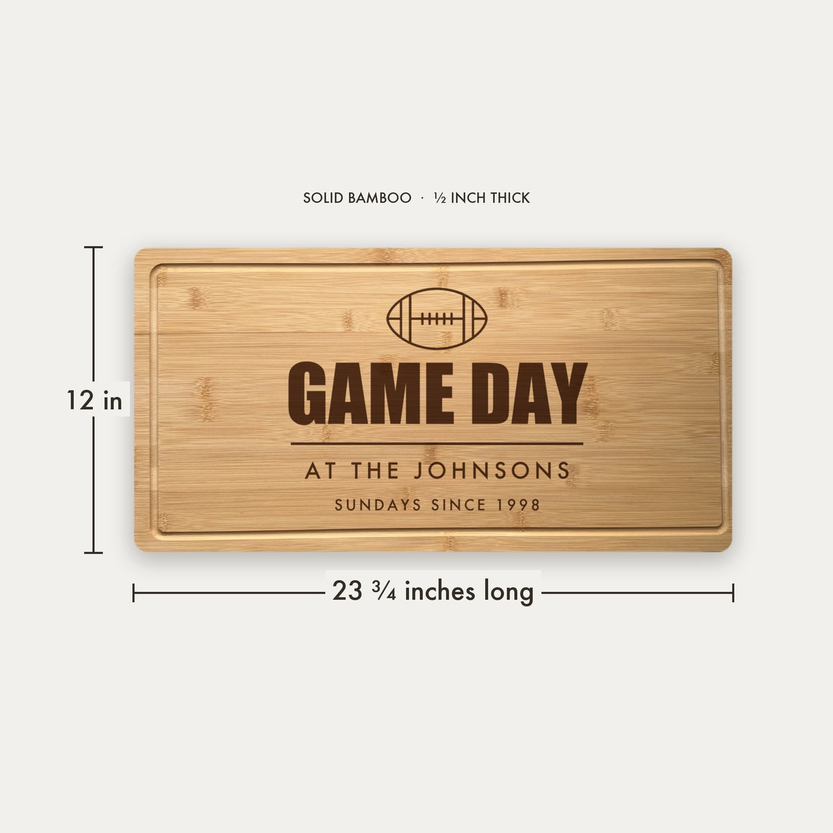 Size guide for the personalized game day cutting board, 23 and three quarter inches long by 12 inches wide in half inch thick solid bamboo.