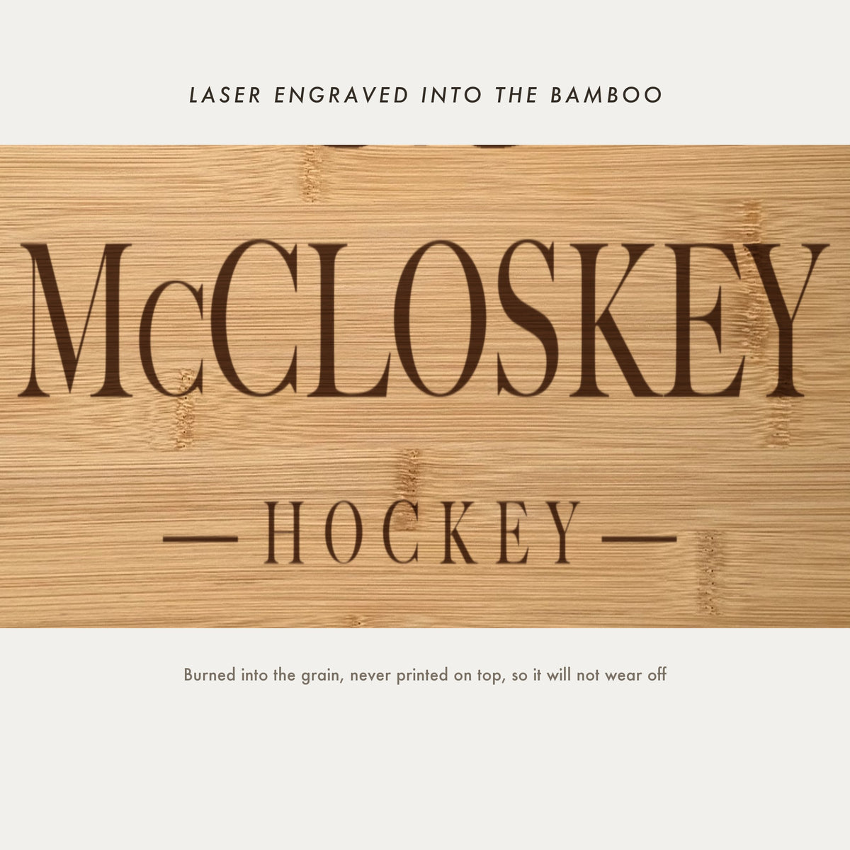 Close view of the family name and the word Hockey laser engraved into the bamboo grain in spaced serif capitals between two fine rules.