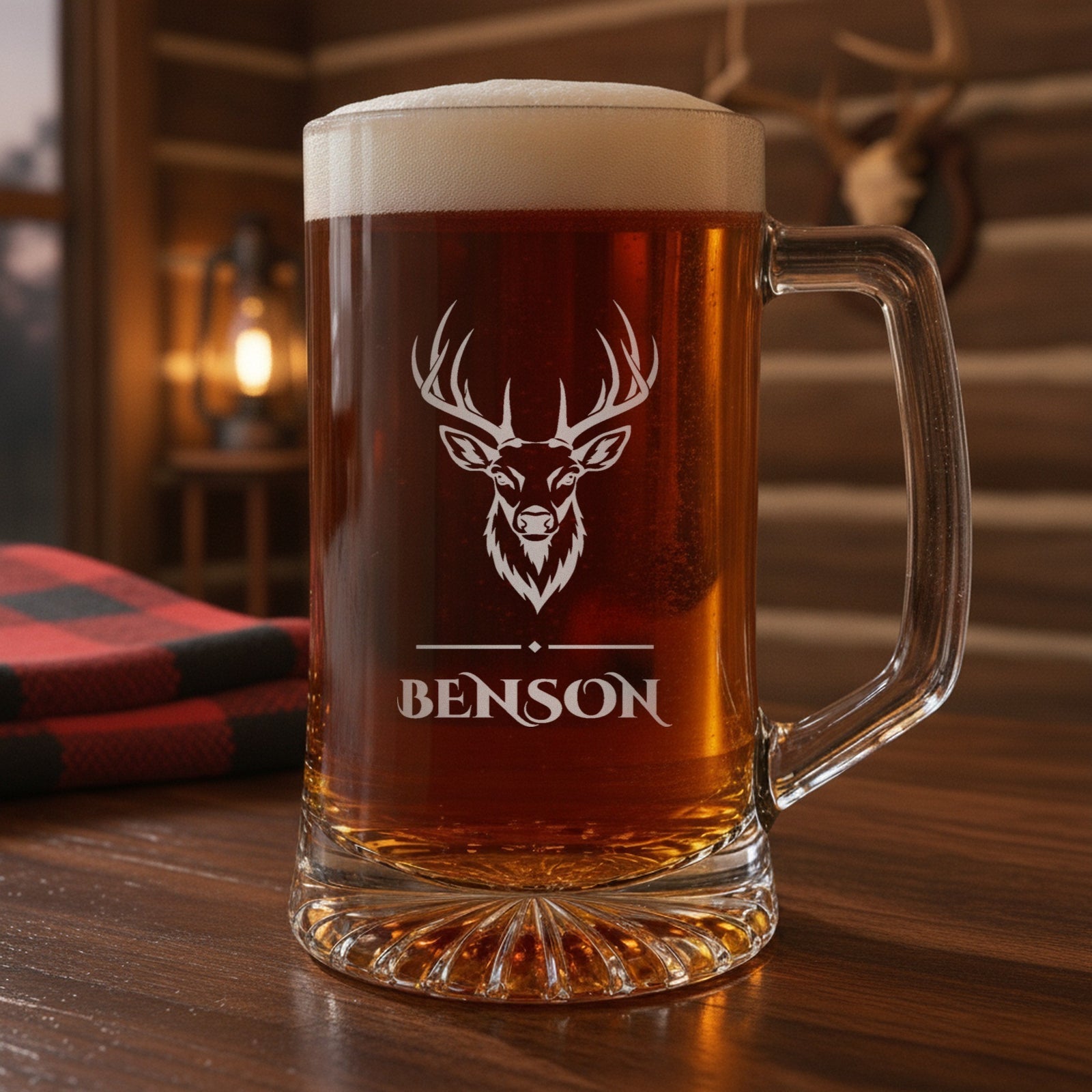 Personalized hunting beer stein on a cabin bar beside an antler mount, a whitetail buck engraved over the name Benson in bold capitals