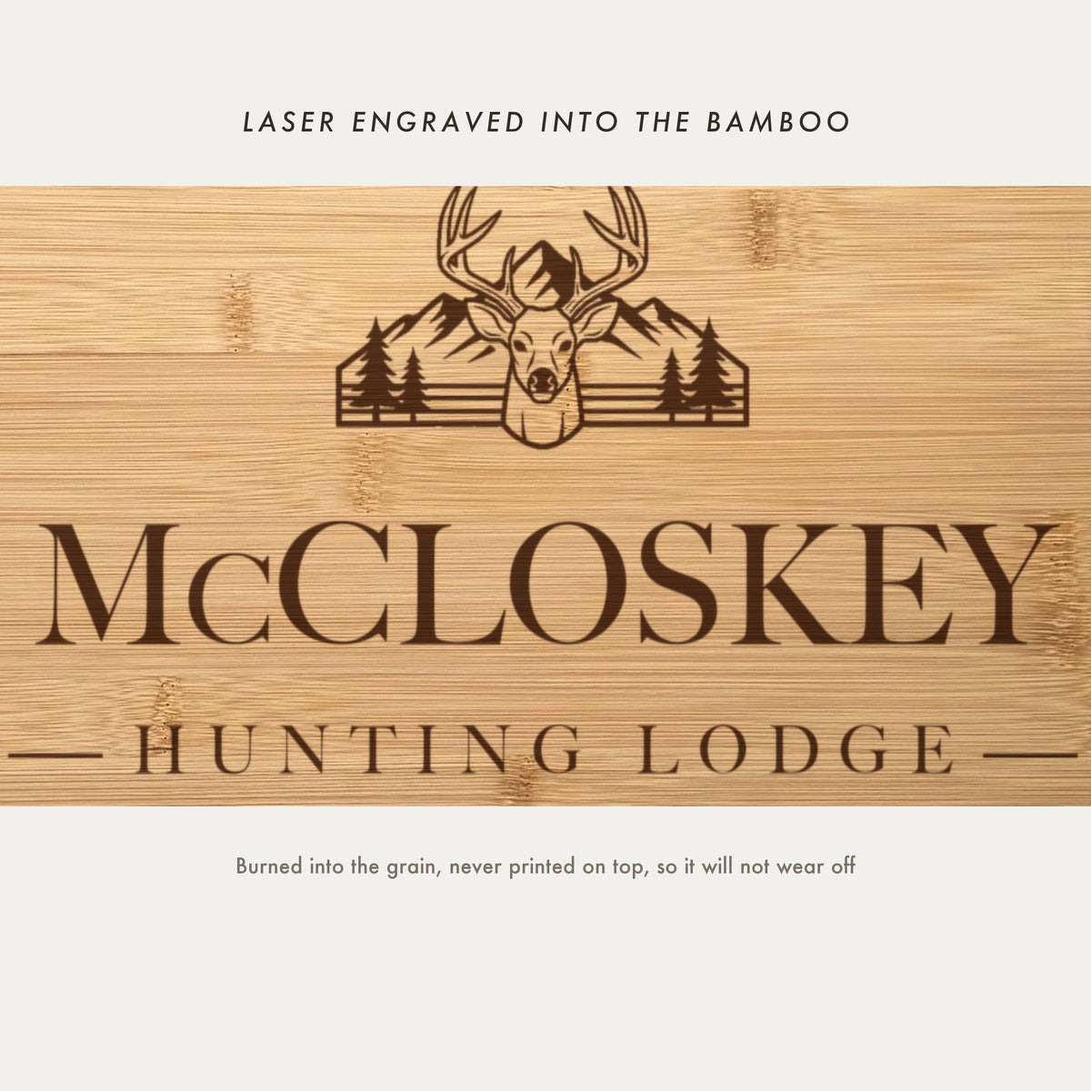 Close view of the buck with antlers, mountain range and pine trees laser engraved into the bamboo grain above the family name.