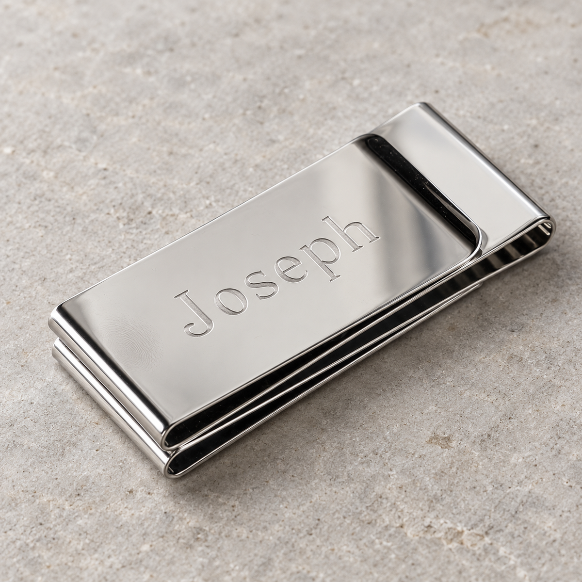 Personalized money clip in mirror-polished stainless steel, the name Joseph engraved across the front, a custom money clip gift for him