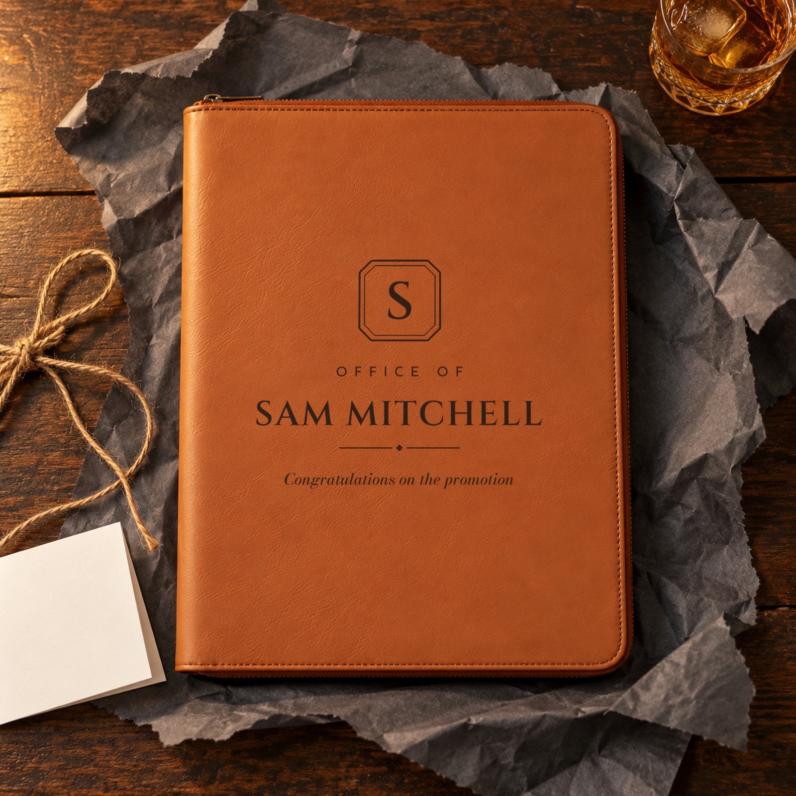 Rawhide personalized padfolio engraved Office of Sam Mitchell, Congratulations on the promotion, unwrapped on charcoal paper as a gift