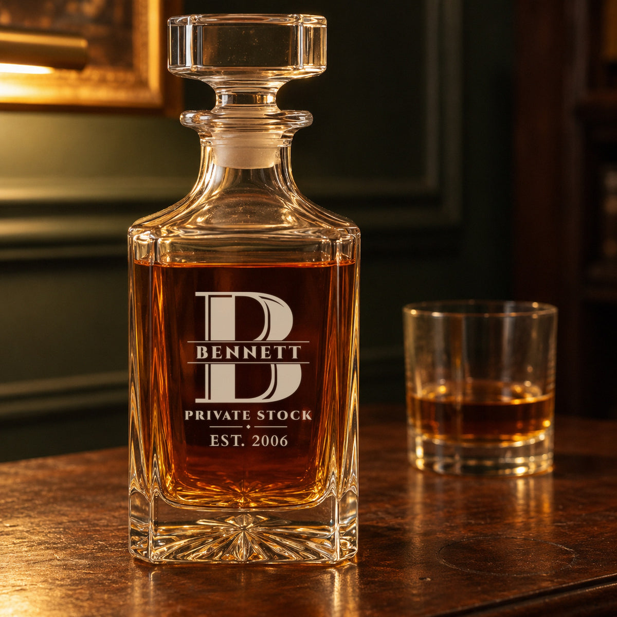 Close-up of a personalized whiskey decanter engraved with a B monogram, Bennett, Private Stock, est. 2006, on a walnut bar cabinet