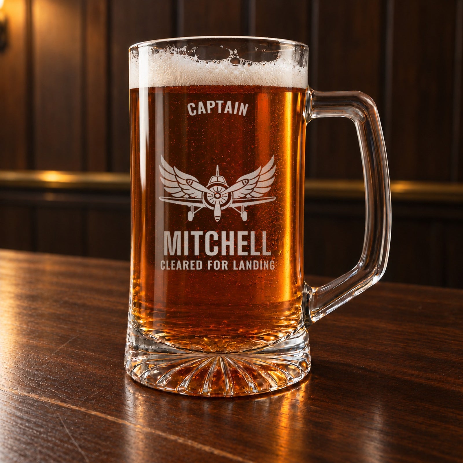 Personalized pilot beer stein on a walnut bar, engraved with a vintage propeller airplane and spread wings: Captain, Mitchell, Cleared for Landing