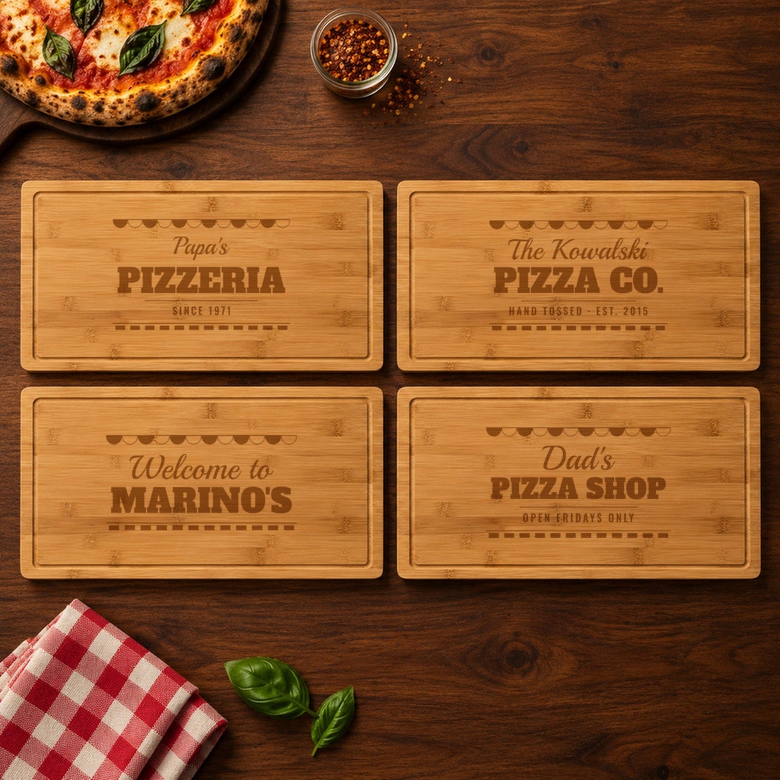 Four engraved pizza boards for pizza lovers on a family table: Papa's Pizzeria, The Kowalski Pizza Co., Welcome to Marino's and Dad's Pizza Shop
