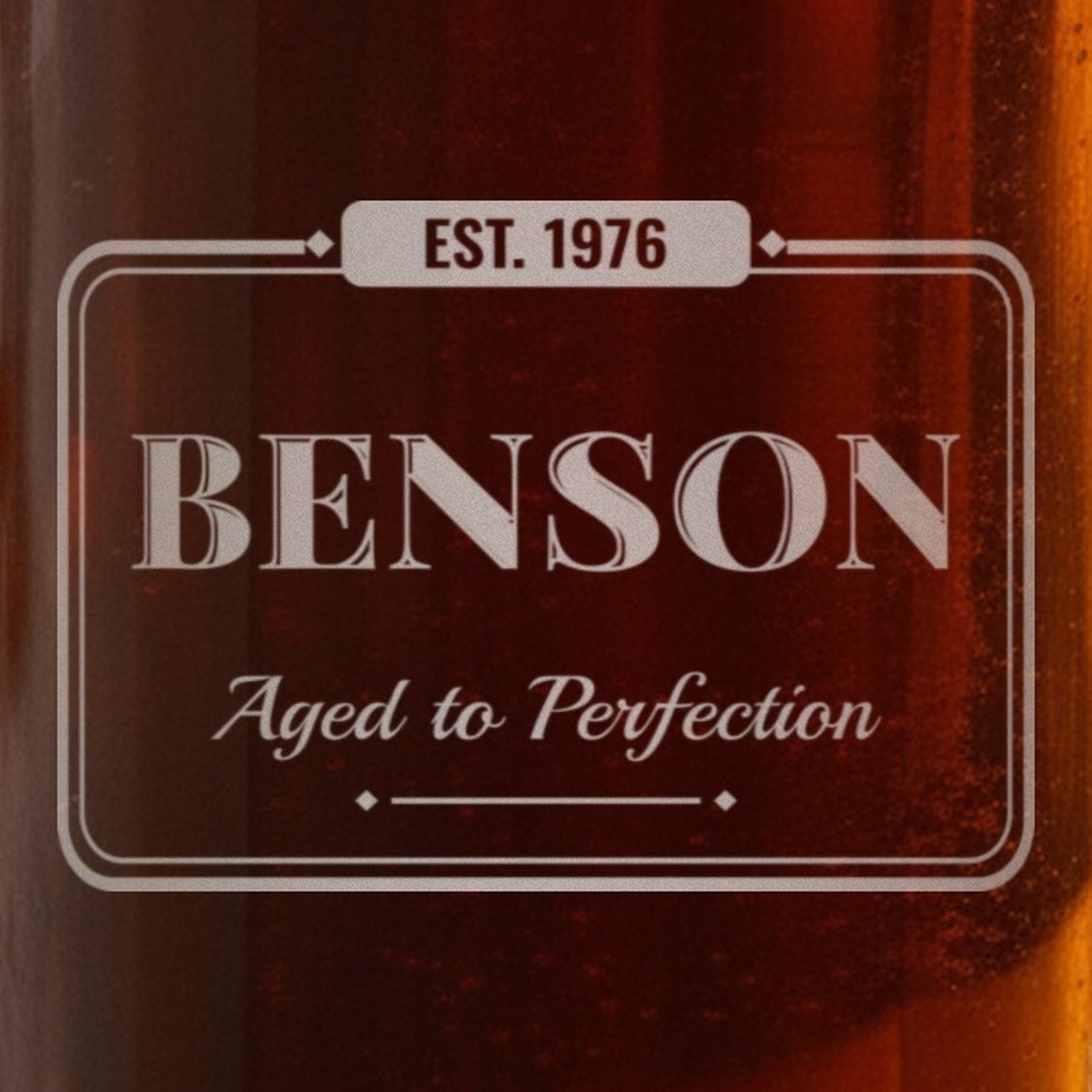 Close-up of the frosted laser engraving on the birthday beer stein: EST. 1976 in the tab, Benson in vintage capitals and Aged to Perfection in script