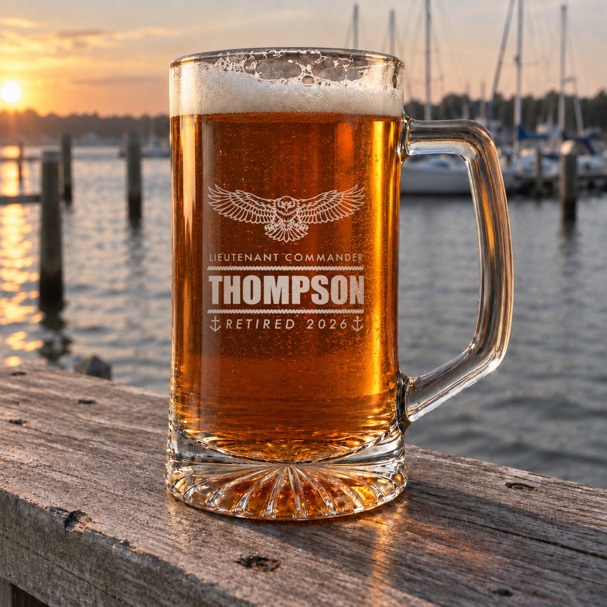 Personalized Navy retirement beer stein on a weathered dock rail at a marina at sunset, engraved Lieutenant Commander, Thompson, Retired 2026