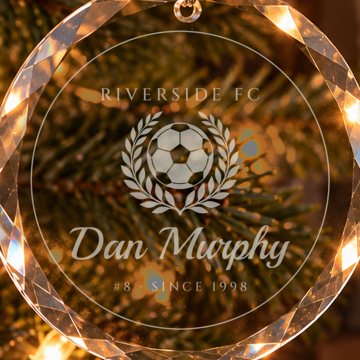 Close-up of the frosted engraving on the soccer Christmas ornament: a ball in a laurel wreath, RIVERSIDE FC, Dan Murphy, #8 · SINCE 1998