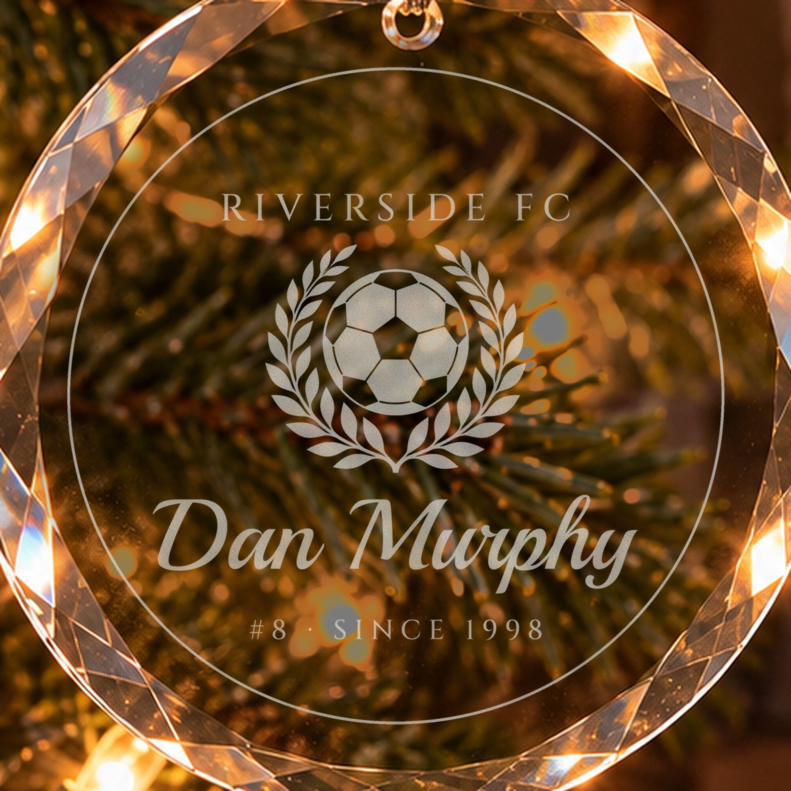 Close-up of the frosted engraving on the soccer Christmas ornament: a ball in a laurel wreath, RIVERSIDE FC, Dan Murphy, #8 · SINCE 1998