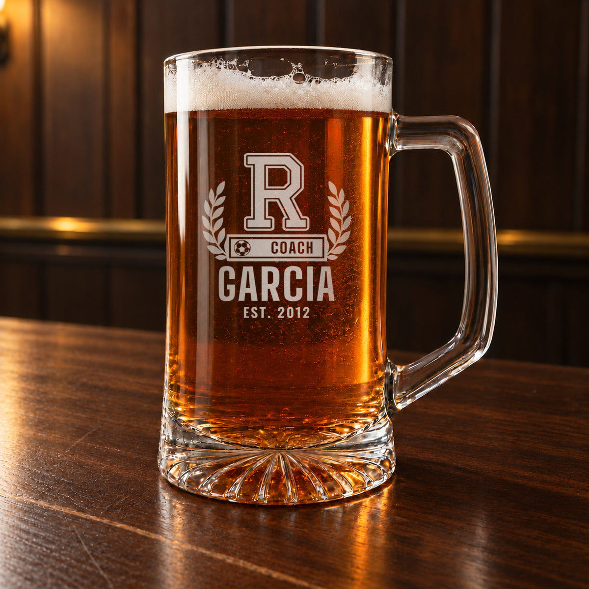 Personalized soccer coach letterman beer stein on a walnut bar, engraved with a varsity letter with laurel and a soccer ball COACH bar: R, Coach, Garcia, Est. 2012