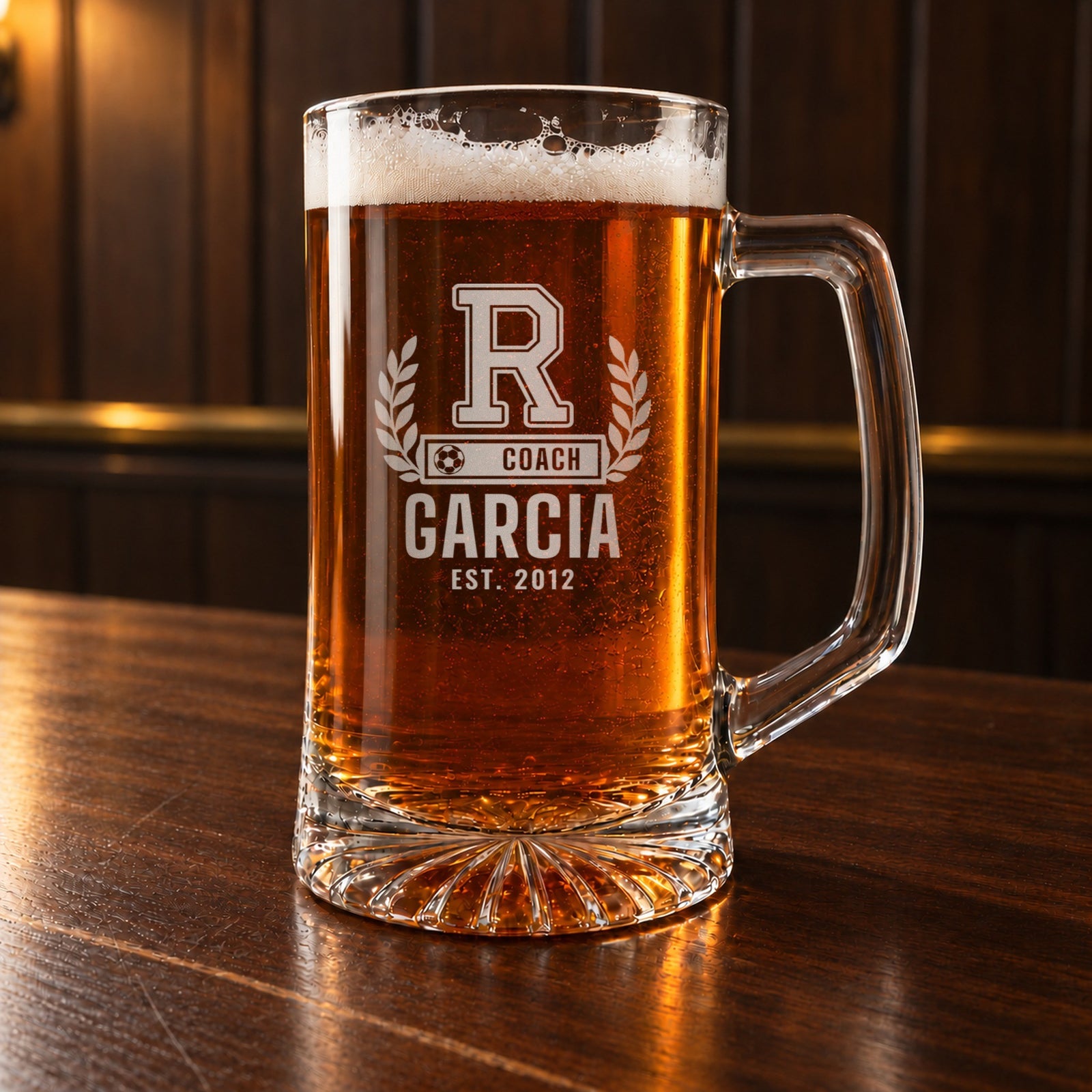 Personalized soccer coach letterman beer stein on a walnut bar, engraved with a varsity letter with laurel and a soccer ball COACH bar: R, Coach, Garcia, Est. 2012