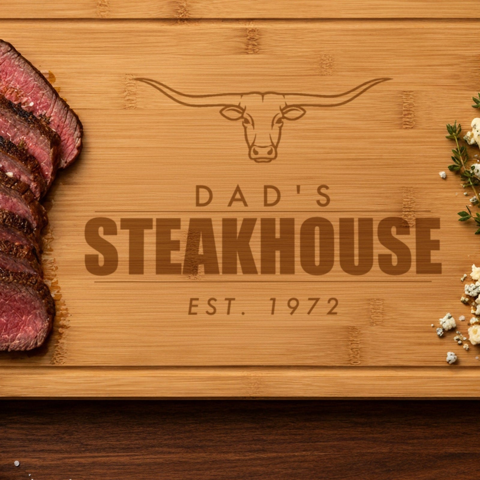 Close-up of the laser engraving on dad's steakhouse cutting board: the longhorn steer, DAD'S and STEAKHOUSE burned into the bamboo grain
