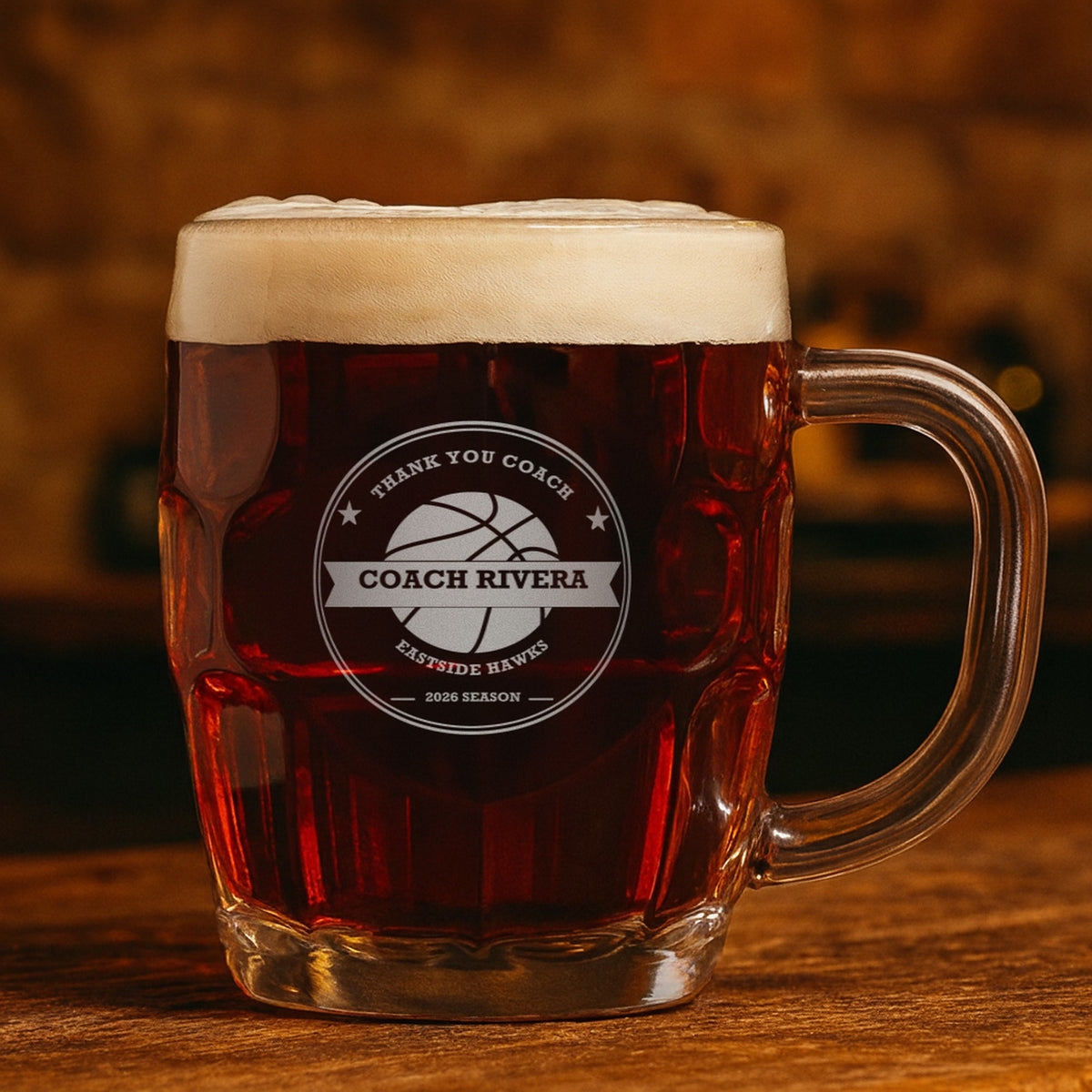 Engraved basketball coach beer stein with dark amber ale showing a second example that reads Thank You Coach, Coach Rivera and 2026 Season
