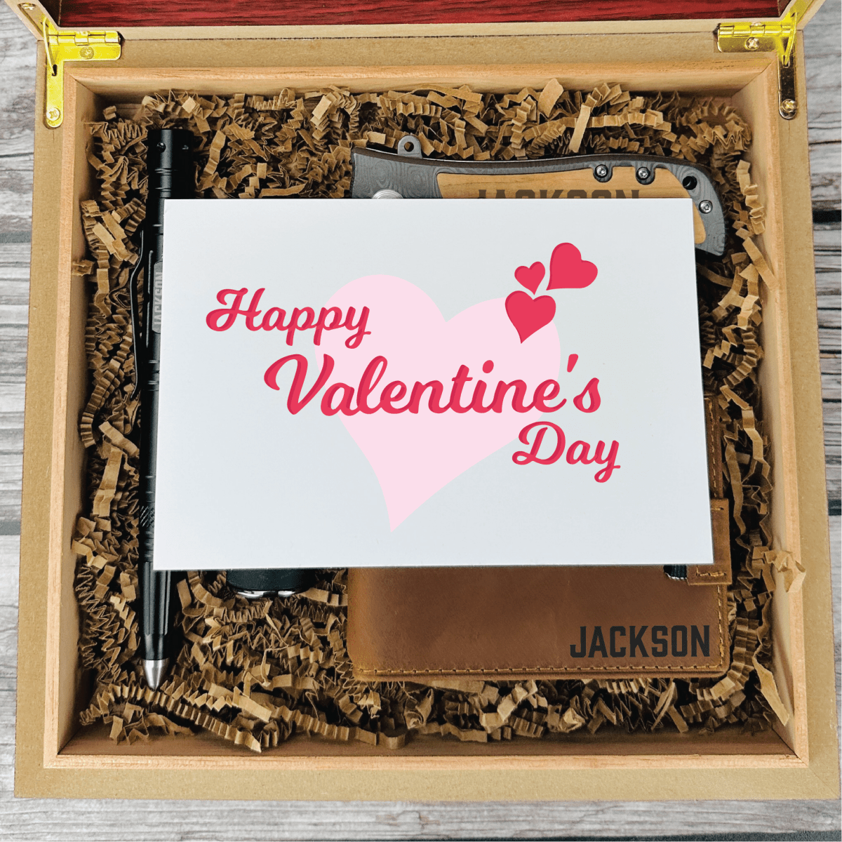 Personalized Valentine’s Day gift set for men featuring a tactical pen, triple torch lighter, wallet, titanium-coated knife, and engraved wooden box with custom name and message