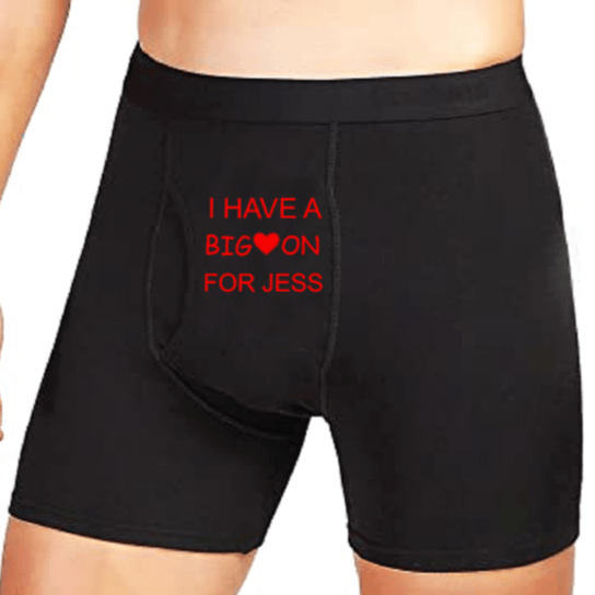 Man wearing black boxer briefs printed in red with I HAVE A BIG heart ON FOR JESS across the front, funny personalized boxers for a husband or boyfriend